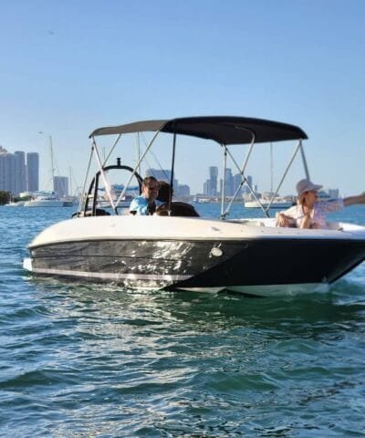 Guests cruising on the Bayliner E18 Black with the downtown Miami skyline behind